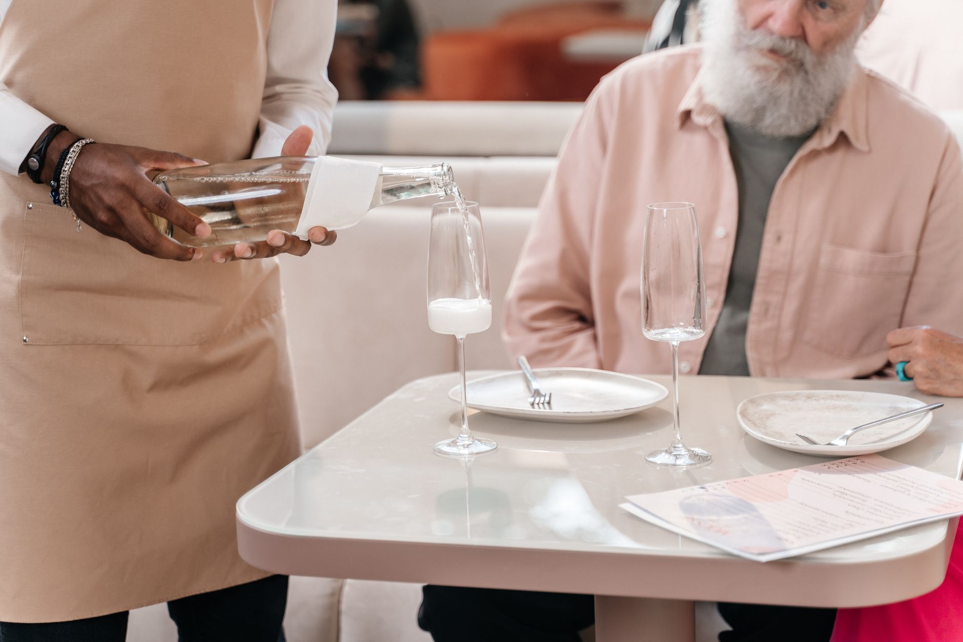 Tjener dækker bord på restaurant